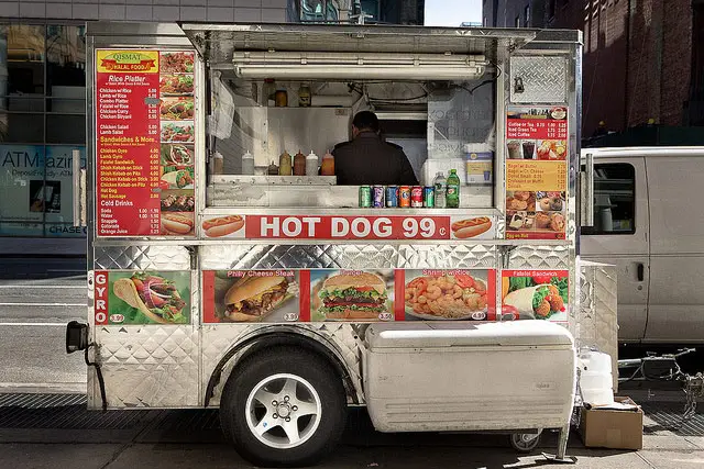 A hot dog vendor serving "disgusting food" to "disgusting people"